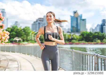 Southeast asian sport woman smiling running jogging at outdoors park exercise wear fitness outfit 129615980