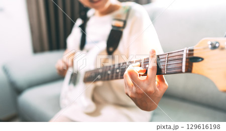 Focus hand of woman on electric guitar chord 129616198