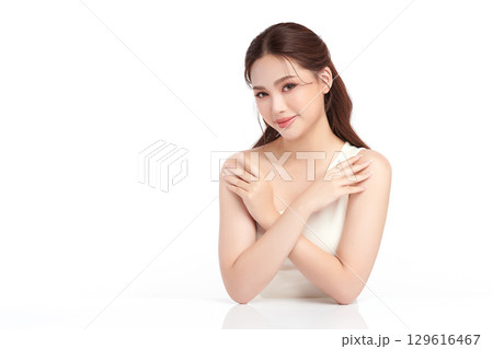 A beautiful young Asian woman with clean, fresh skin against a white background. Skincare, facial treatment, cosmetology, beauty, and spa. An elegant portrait of an Asian woman. 129616467