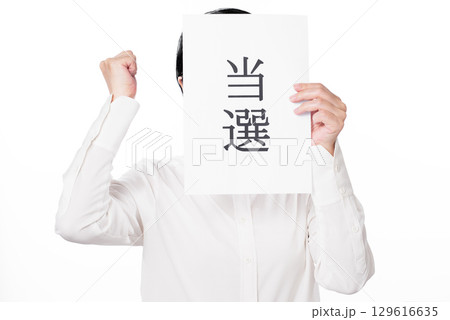 当選と書かれた紙を持つ白いシャツを着た人物 129616635