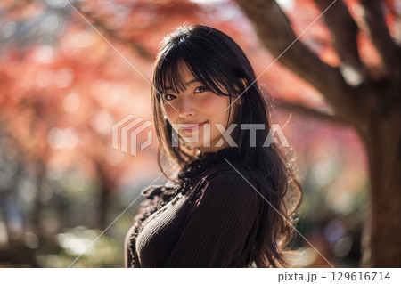 紅葉背景の若い女性 129616714