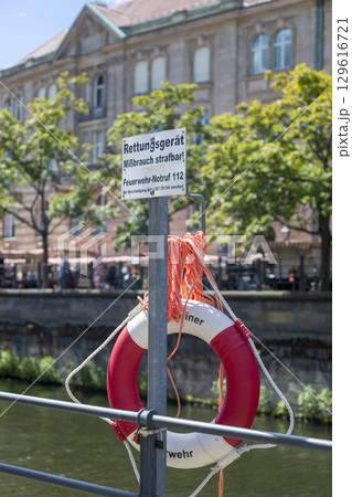 Berlin, Germany - July 01, 2018: Lifebuoy on the embankment of the Spree river in Berlin Berlin, Germany - July 01, 2018: Lifebuoy on the embankment of the Spree river in Berlin 129616721