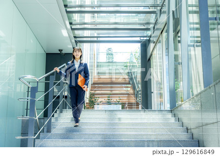 ファイルを持って歩くスーツ姿の女性 ファイルを持って歩くスーツ姿の女性 129616849