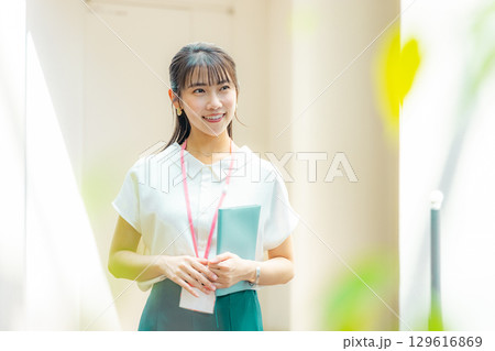 ファイルを持って考える若い女性 129616869