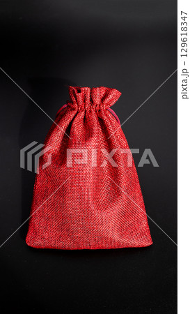 Crimson textured drawstring bag on black background Crimson textured drawstring bag on black background 129618347
