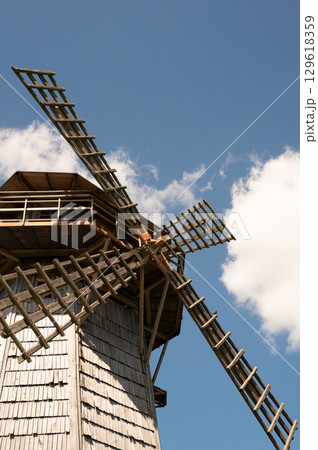 Historic wooden windmill against blue sky 129618359