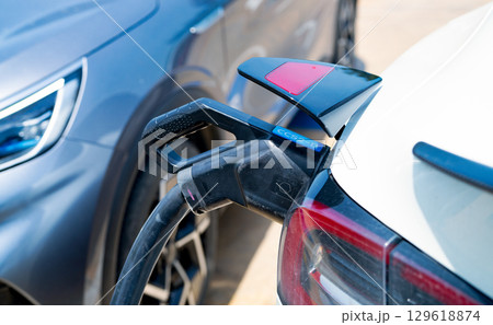 Electric vehicle charging station. Sustainable transport infrastructure with clean energy battery charging point for eco-friendly cars. Modern EV charging station. Zero emission transportation. 129618874