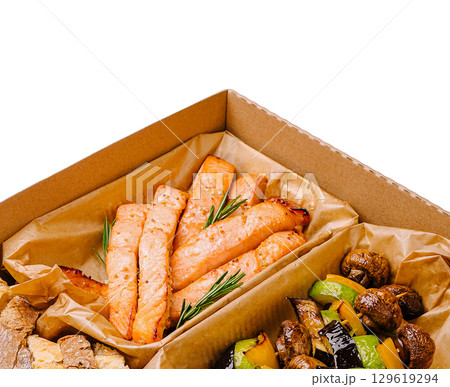 Salmon fillets and grilled vegetables in a takeout box from a restaurant 129619294