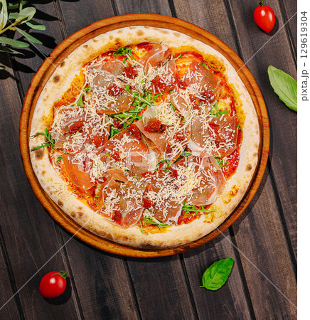 Delicious fresh pizza topped with ham and cheese on wooden table Delicious fresh pizza topped with ham and cheese on wooden table 129619304