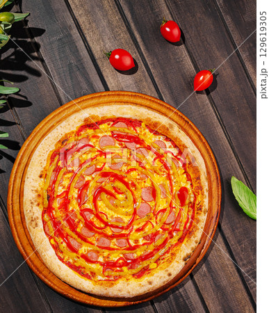 Pizza topped with pepperoni and ketchup on a wooden surface in bright sunlight Pizza topped with pepperoni and ketchup on a wooden surface in bright sunlight 129619305