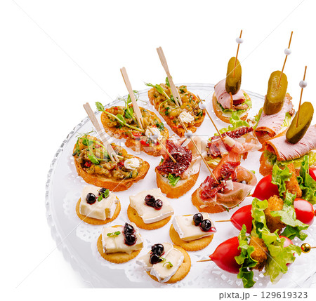Elegant tapas platter featuring gourmet appetizers and fresh garnishes Elegant tapas platter featuring gourmet appetizers and fresh garnishes 129619323