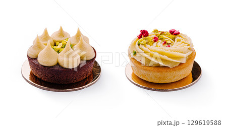 Decadent desserts featuring pistachio and cream toppings on elegant bases Decadent desserts featuring pistachio and cream toppings on elegant bases 129619588