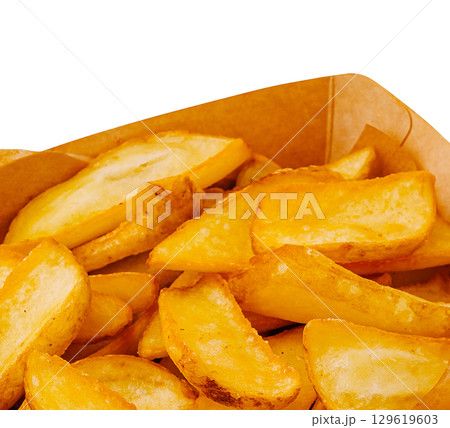 Crispy golden fries served in a cardboard container at a food festival 129619603