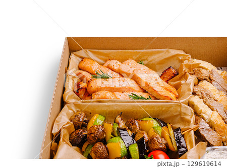 Healthy grilled salmon with vegetables in a takeout box from a local restaurant 129619614