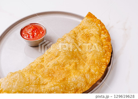 Crispy snack served with tangy sauce on a plate at a local eatery 129619628