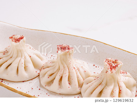 Delicious khinkali served on a decorative plate in a modern setting 129619632