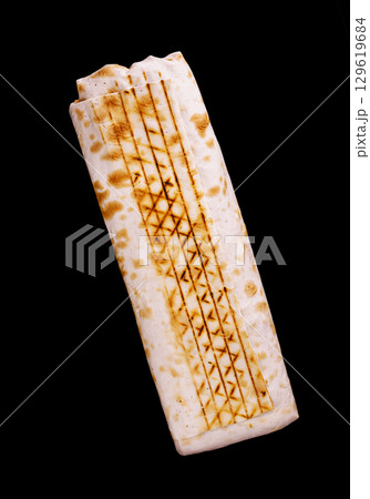Delicious grilled flatbread with char marks displayed on a black background 129619684