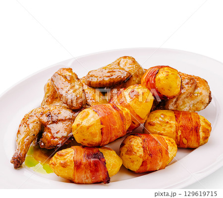 Grilled chicken with savory side of roasted potatoes wrapped in bacon Grilled chicken with savory side of roasted potatoes wrapped in bacon 129619715