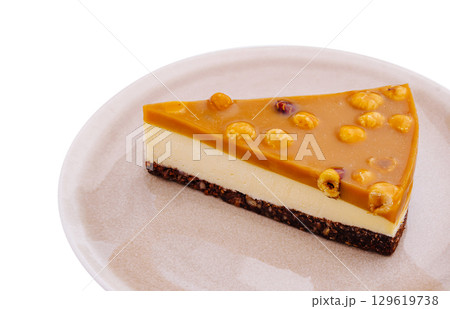Delicious slice of caramel dessert garnished with nuts on a rustic plate Delicious slice of caramel dessert garnished with nuts on a rustic plate 129619738