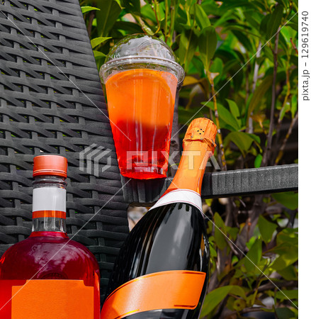 Party drinks displayed on a garden table with vibrant green foliage Party drinks displayed on a garden table with vibrant green foliage 129619740