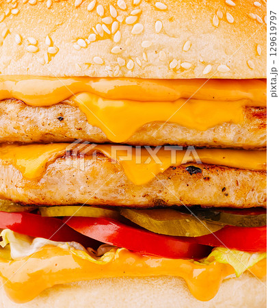 Juicy double cheeseburger with melted cheese and fresh toppings Juicy double cheeseburger with melted cheese and fresh toppings 129619797