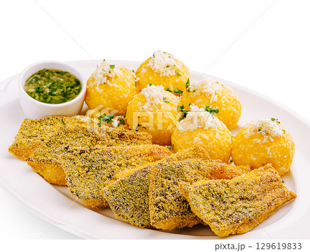 Delicious fried fish served with yellow plantain balls and dipping sauce Delicious fried fish served with yellow plantain balls and dipping sauce 129619833