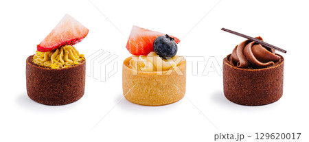 Assorted tarts with fruit and cream on a white background in a dessert display 129620017