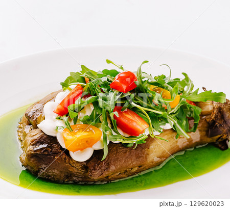 Delicious roasted vegetable dish with fresh herbs and colorful toppings Delicious roasted vegetable dish with fresh herbs and colorful toppings 129620023
