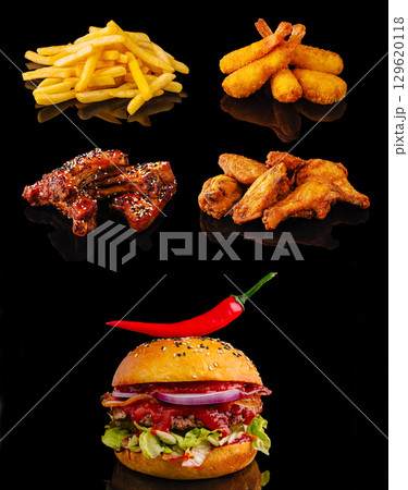 A spicy gourmet burger with fries, crispy shrimp, glazed ribs, and golden chicken wings 129620118