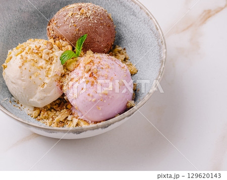 Different flavors of ice cream served in a bowl with toppings Different flavors of ice cream served in a bowl with toppings 129620143