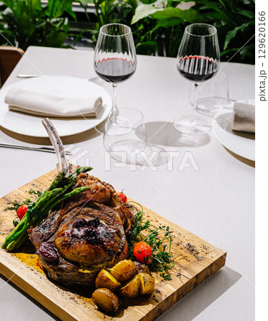 Savory grilled steak with vegetables served on wooden platter 129620166