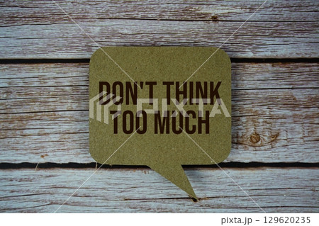 Don't Think Too Much text with speech bubble top view on wooden background 129620235