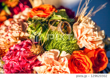 Wedding rings on the bride's bouquet in the autumn theme 129620302