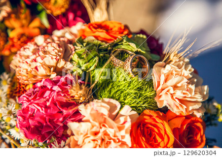 Wedding rings on the bride's bouquet in the autumn theme 129620304