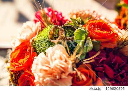 Wedding rings on the bride's bouquet in the autumn theme 129620305