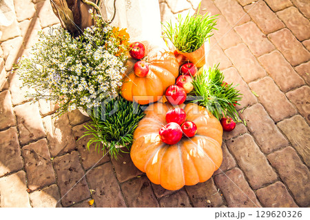 Wedding arch for off-site wedding ceremony, decorated in autumn theme with pumpkins 129620326