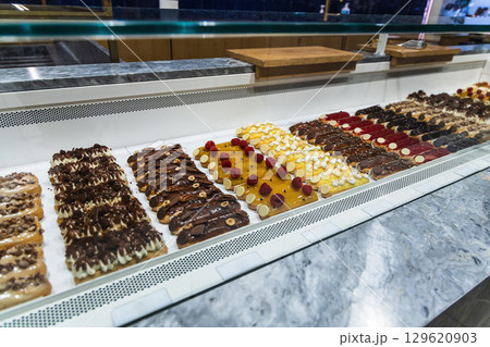 Various assortment of desserts confectionery on the counter in a bakery Various assortment of desserts confectionery on the counter in a bakery 129620903