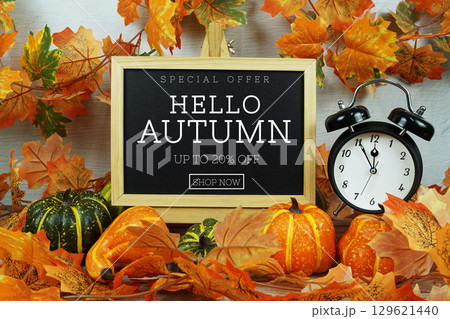 Autumn Sale 20% text with alarm clock and maple leaf decoration on wooden background Autumn Sale 20% text with alarm clock and maple leaf decoration on wooden background 129621440