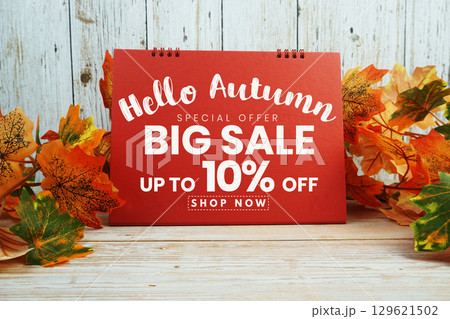 Hello Autumn Big Sale 10% text with maple leaf decorated on wooden background 129621502