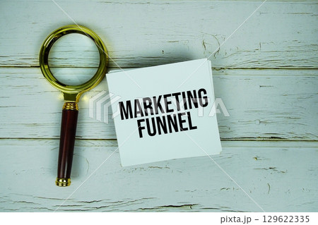 Marketing Funnel text message on paper with magnifying glass on wooden background 129622335