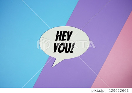 Hey You! text on speech bubble top view on blue, purple and pink geometric background Hey You! text on speech bubble top view on blue, purple and pink geometric background 129622661
