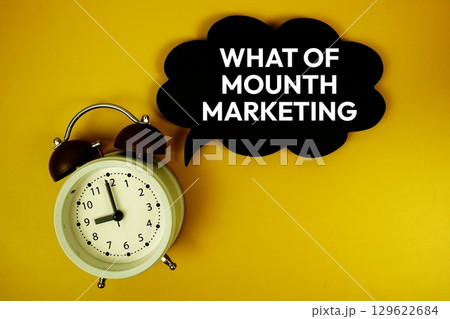 What Of Mounth Marketing text on speech bubble with alarm clock top view on yellow background 129622684