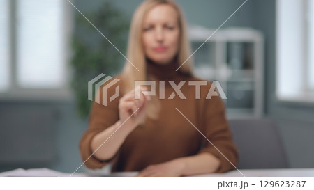 A woman is watching holographic screens. 129623287