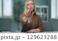 A woman is watching holographic screens. 129623288