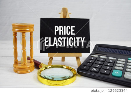 Price Elasticity text with magnifying glass and calculator on wooden background 129623544