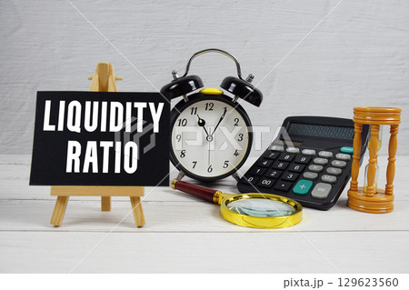 Liquidity Ratio text with alarm clock and calculator on wooden background 129623560