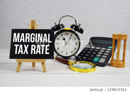 Marginal Tax Rate text with magnifying glass and calculator on wooden background Marginal Tax Rate text with magnifying glass and calculator on wooden background 129623561