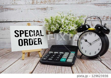 Special Order text with alarm clock and calculator on wooden background 129623936