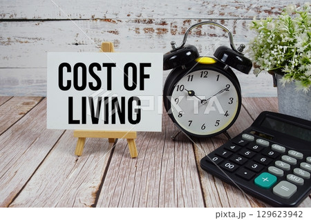 Cost Of Living text with alarm clock and calculator on wooden background 129623942