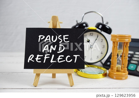 Pause And Reflect text with magnifying glass and calculator on wooden background Pause And Reflect text with magnifying glass and calculator on wooden background 129623956